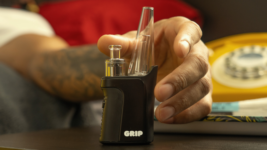 A member of Randy’s community reaching for a sleek GRIP vaporizer placed on a table. The stylish, modern tool reflects Randy’s commitment to providing practical and innovative accessories for enthusiasts.